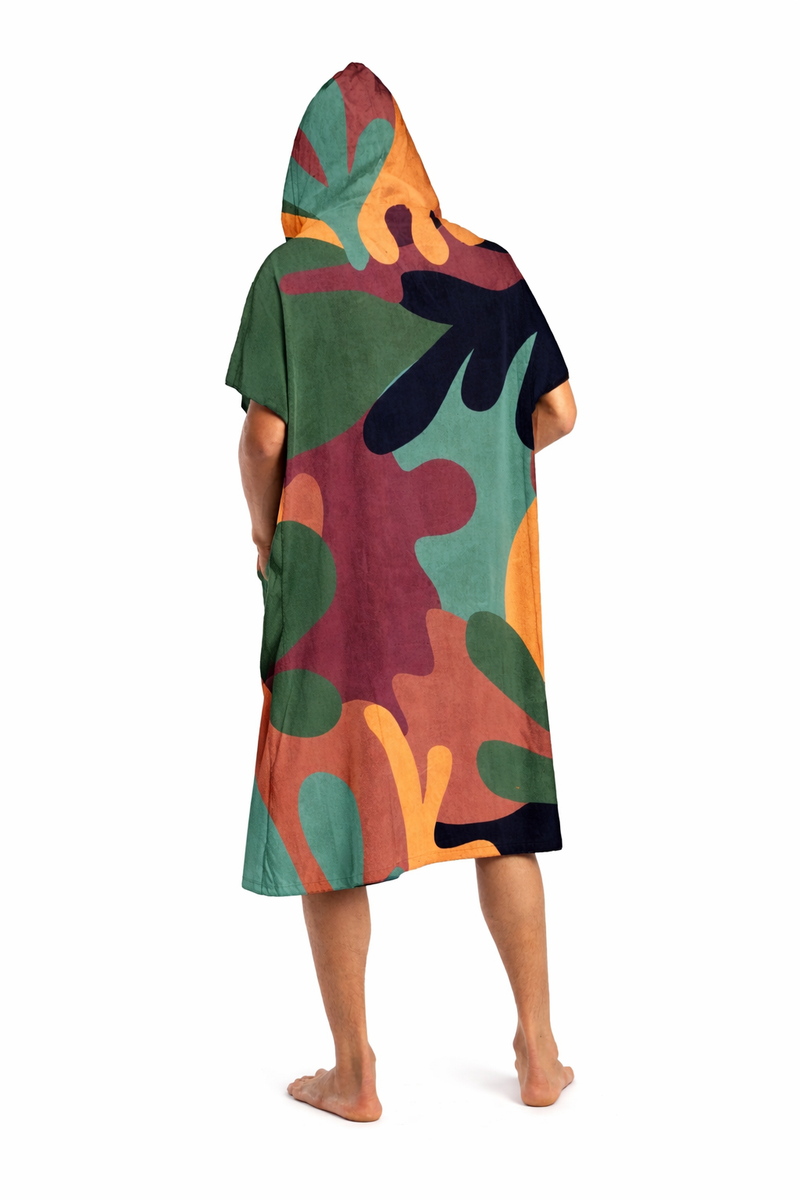 Person wearing a colorful hooded towel with abstract patterns on a white background